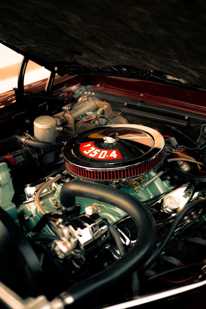 Close-up view of a classic car's engine bay with chrome details and air filter.